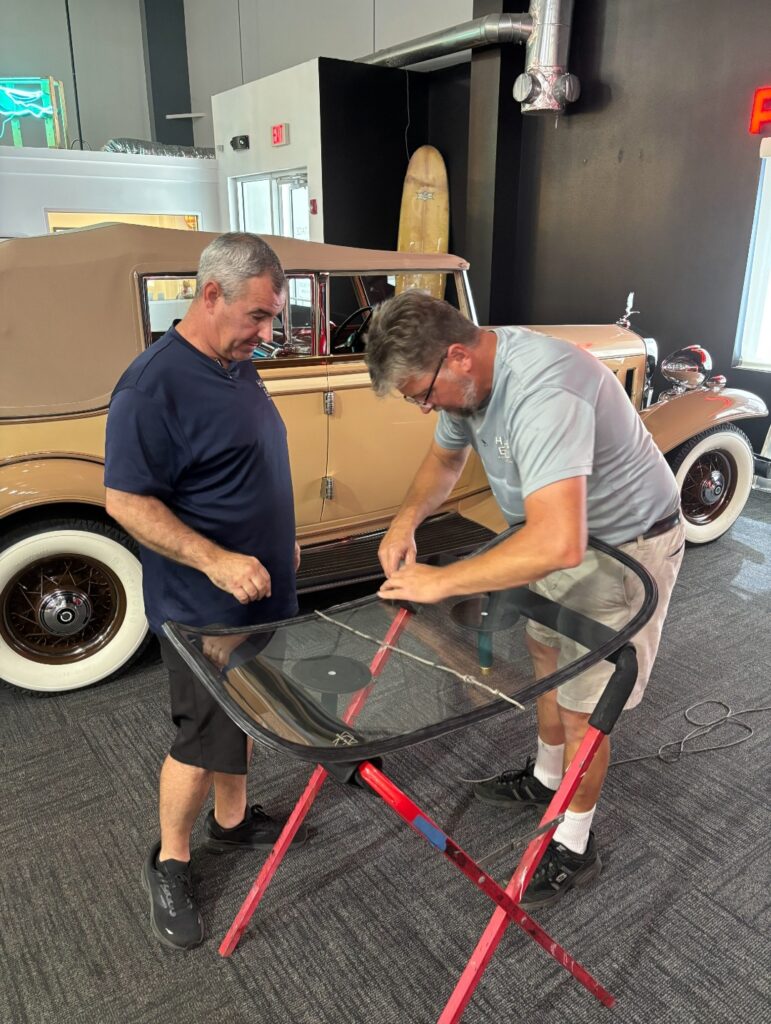 Two men waiting over a windshield on a rack
